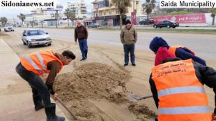 بالصور : فرق بلدية صيدا رفعت رمولا قذفتها رياح العاصفة من الشاطىء   وغطت جانبا من طريق البوليفار البحري